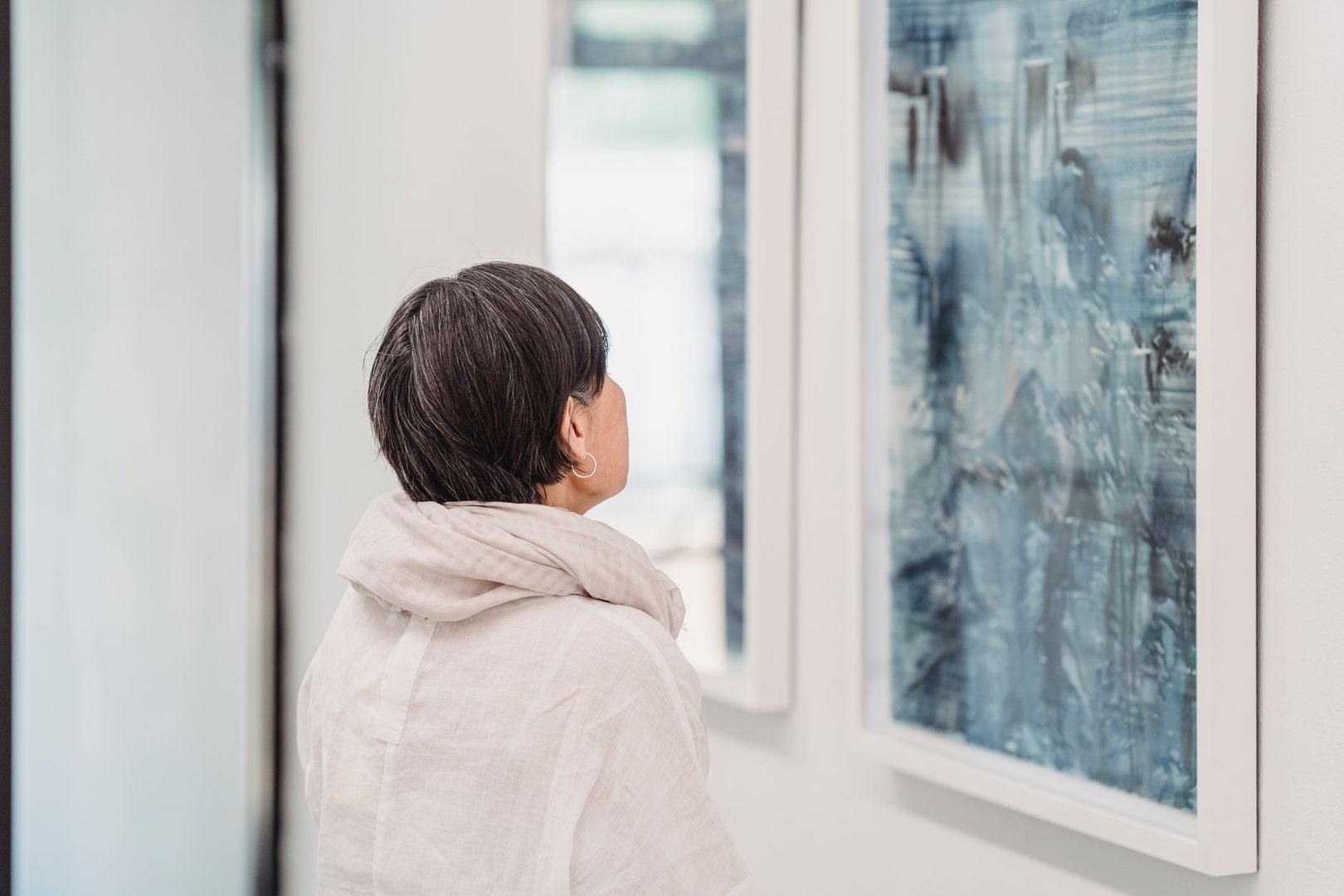 Visiteuse contemplant lentement une œuvre dans un musée